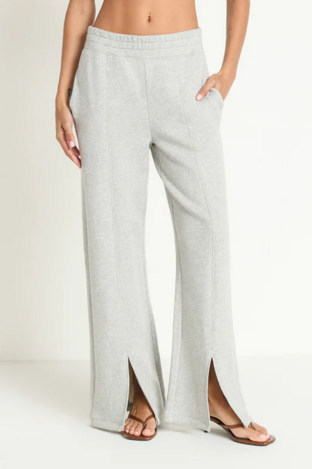 Grey wide-leg sweatpants worn by a person on a white background