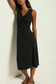 Woman wearing a black sleeveless dress against a white background