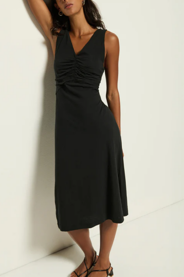 Woman wearing a black sleeveless dress against a white background