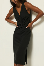 Woman wearing a black dress against a plain background