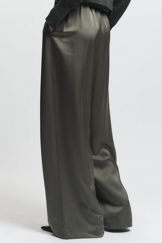 Dark green wide-leg pants worn by a person on a white background
