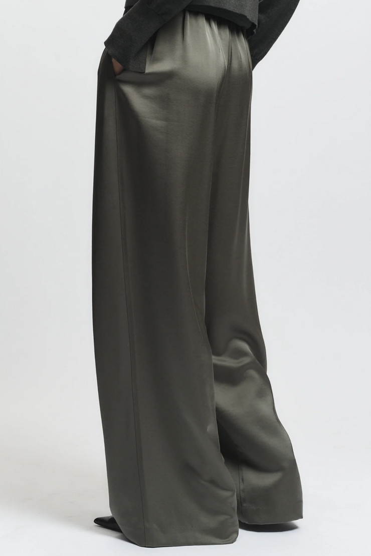 Dark green wide-leg pants worn by a person on a white background