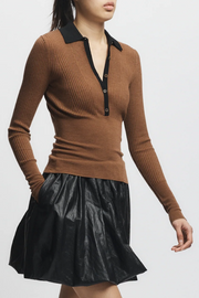 Brown ribbed sweater with black collar and black leather skirt on a white background