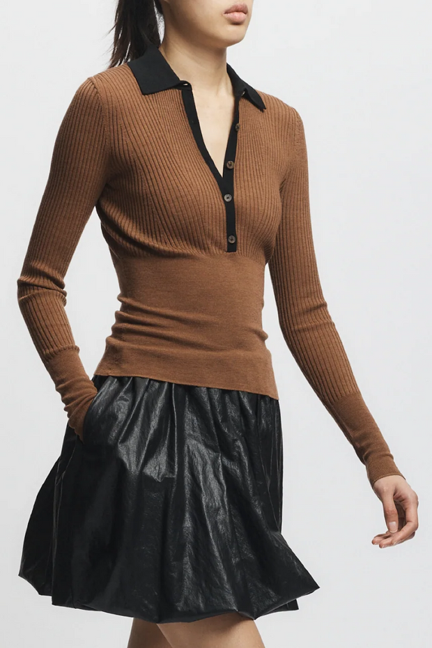 Brown ribbed sweater with black collar and black leather skirt on a white background