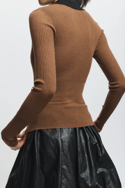 Brown ribbed sweater worn by a person on a white background