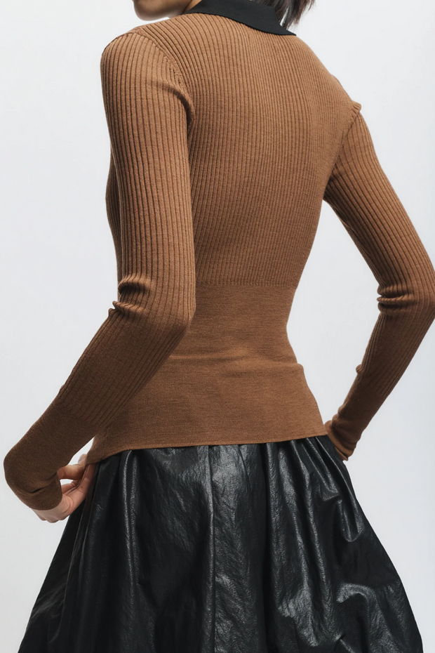 Brown ribbed sweater worn by a person on a white background