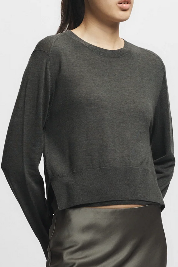 Person wearing a Olive  sweater with a plain background