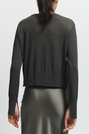 Olive sweater worn by a person on a white background