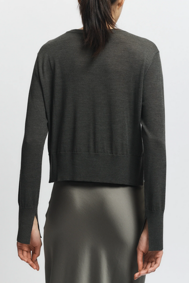 Olive sweater worn by a person on a white background