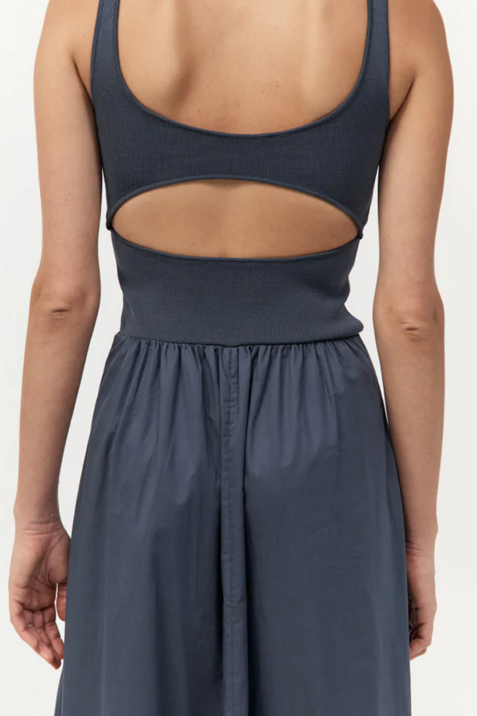 Navy blue dress with cut-out back on a white background