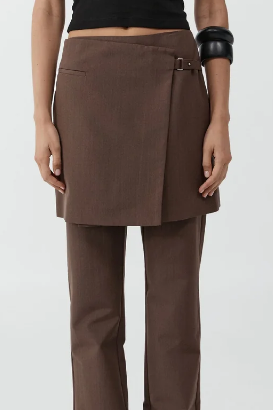 Brown skirt and pants worn by a person on a white background