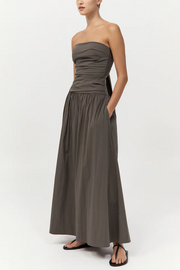 Woman wearing a strapless khaki dress on a white background