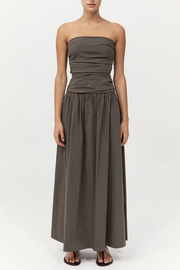 Woman wearing a strapless khaki dress on a white background