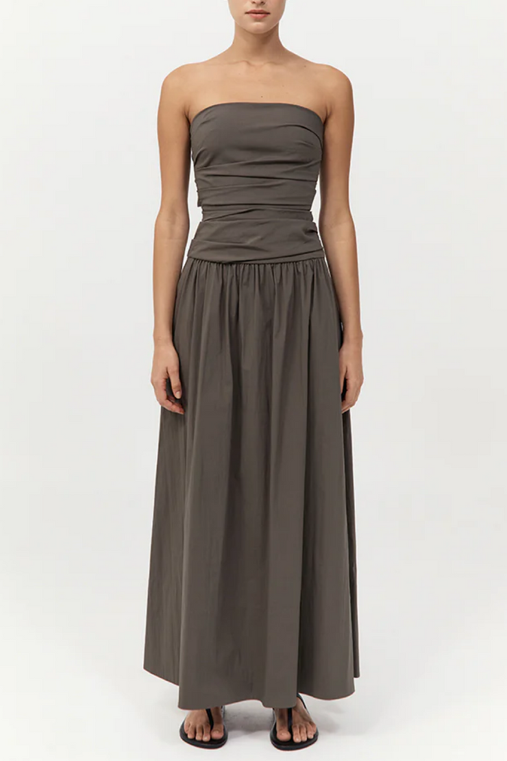 Woman wearing a strapless khaki dress on a white background