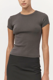 Person wearing a khaki t-shirt and black skirt on a white background