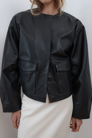 Black leather jacket worn by a person on a plain background
