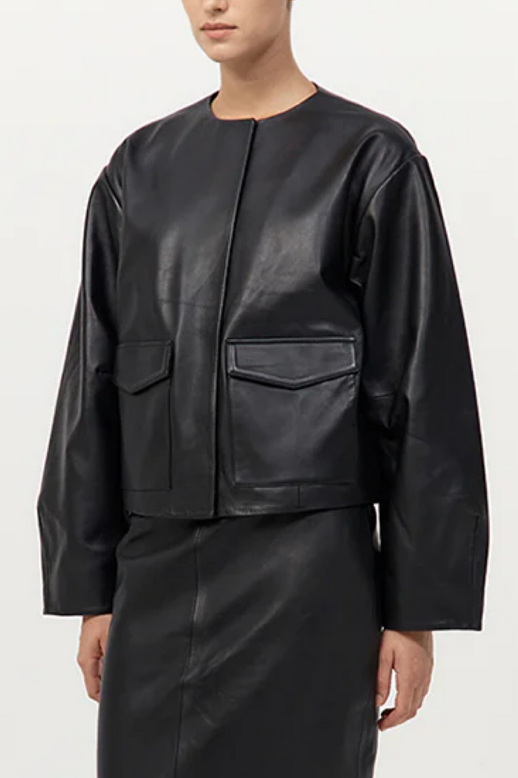 Person wearing a black leather jacket and pants on a white background