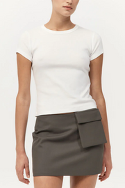 Person wearing a white t-shirt and gray skirt on a plain background