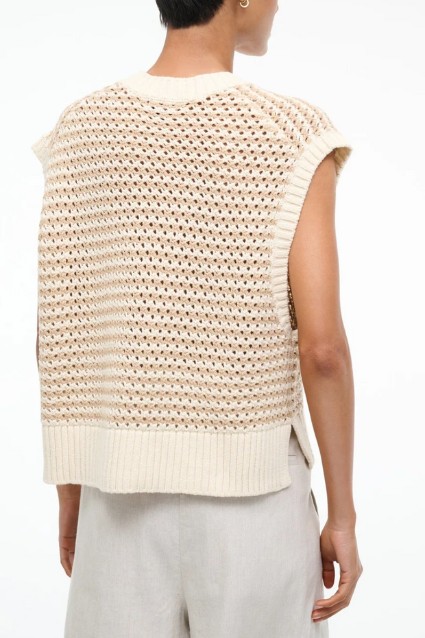 Beige knitted sleeveless top worn by a person on a white background