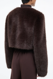 Brown fur jacket worn by a person on a white background