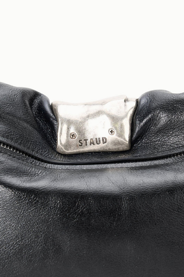 Black leather handbag with a silver 'Staud' logo on a white background