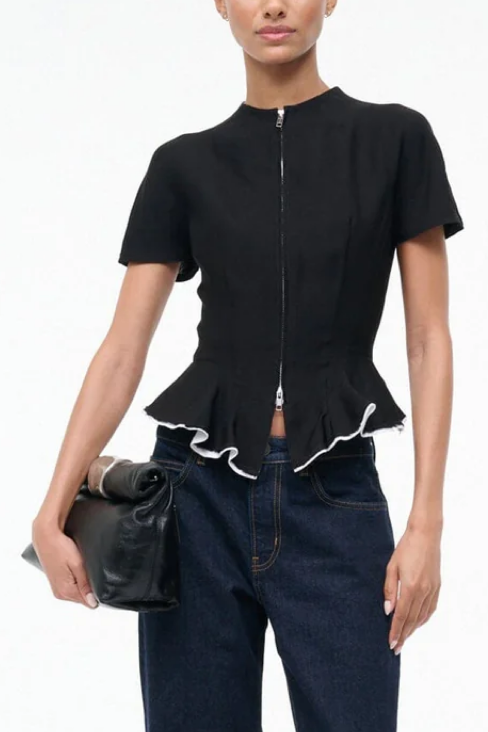 Black peplum top with white trim worn by a model on a white background