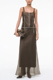 Woman wearing a long brown dress with a white background