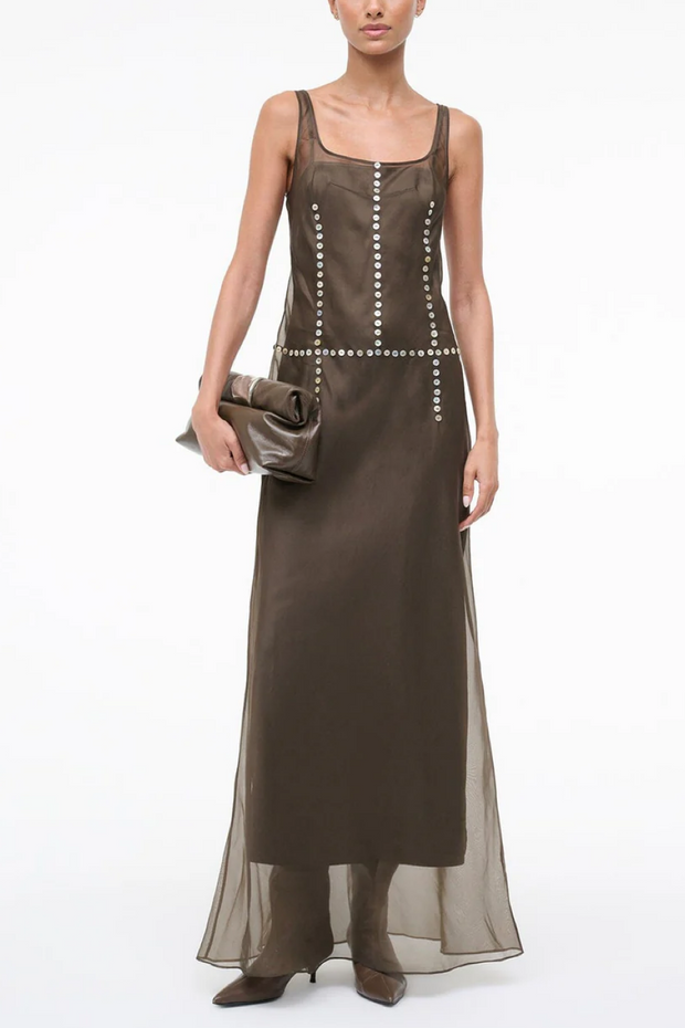 Woman wearing a long brown dress with a white background