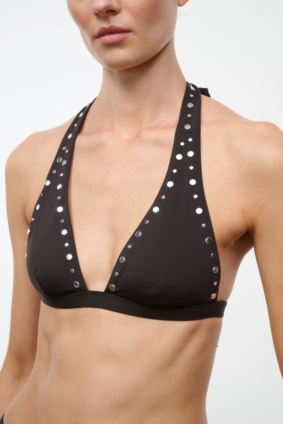 Brown bikini top with silver studs on a plain background
