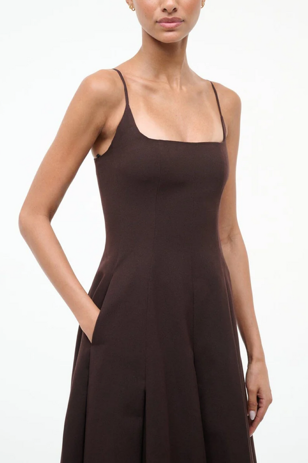 Woman wearing a brown slip dress on a white background