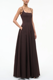 Woman wearing a long brown dress on a white background