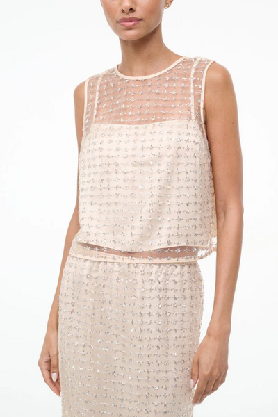 Woman wearing a two tone beaded beaded top on a white background