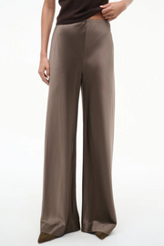 Silk truffle colored wide-leg pants worn by a person on a white background