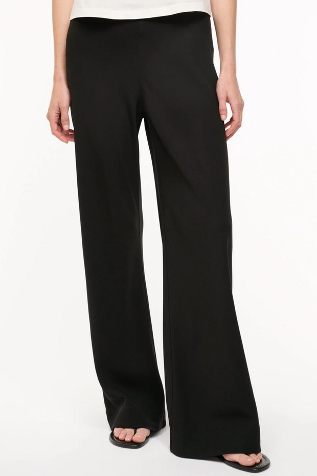 Black wide-leg pants worn by a person on a white background