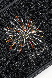 Close-up of a black beaded clutch with a starburst pattern