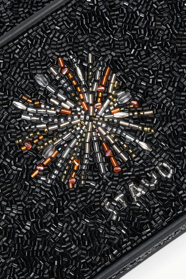 Close-up of a black beaded clutch with a starburst pattern