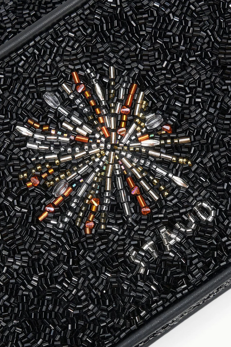 Close-up of a black beaded clutch with a starburst pattern