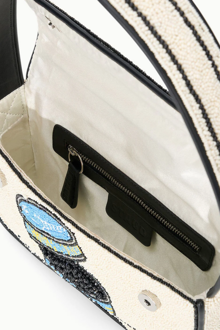 Close-up of a handbag with decorative elements and a visible brand logo.