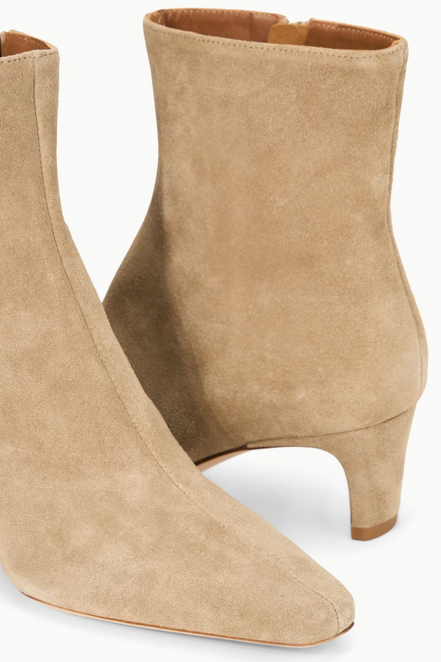 Pair of beige ankle boots on a white background