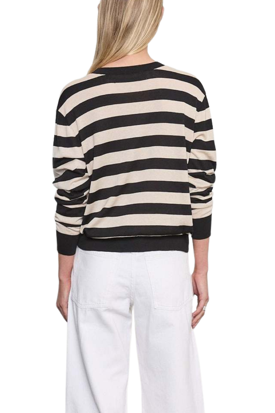 Person wearing a black and beige striped sweater with white pants on a white background