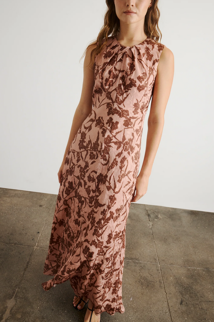 Woman wearing a floral dress against a plain background