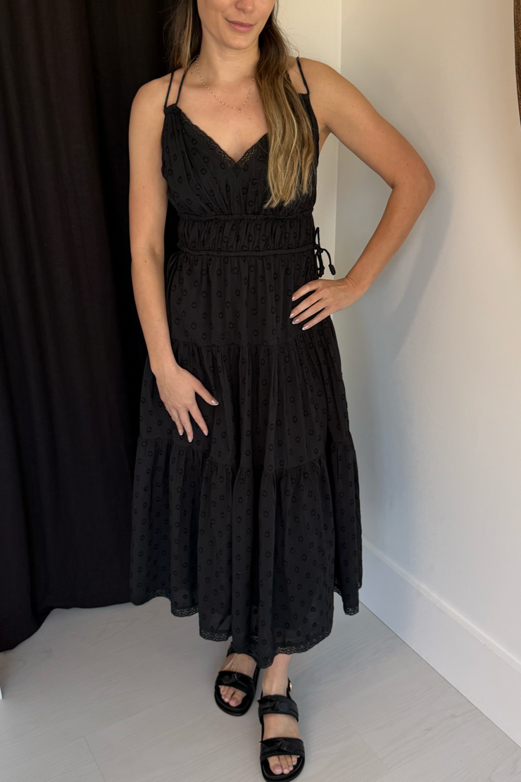 Woman wearing a black dress against a plain background