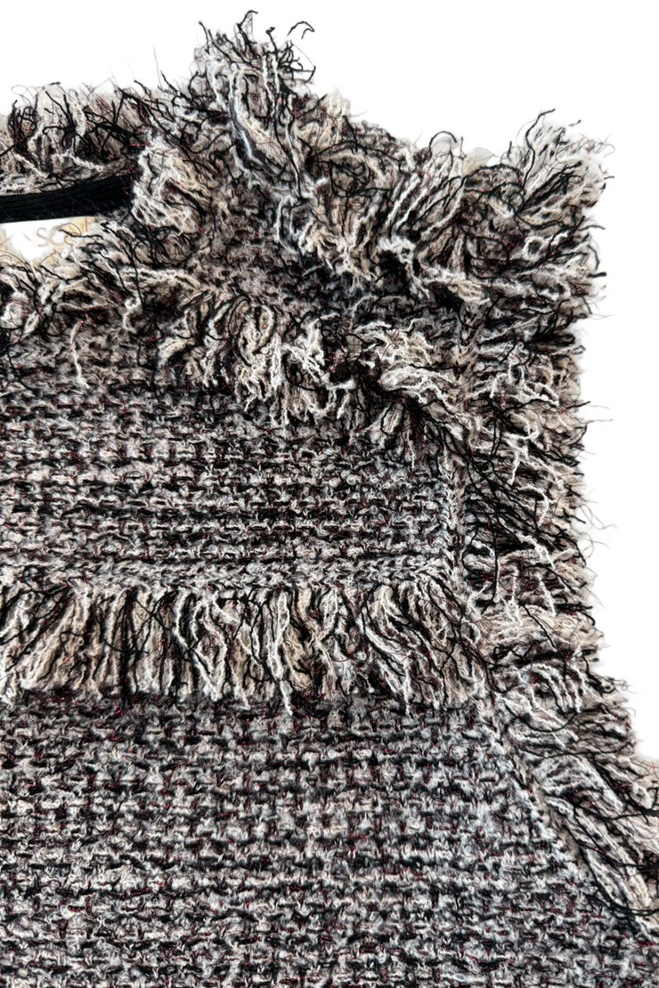 Close-up of a textured rug with fringe details