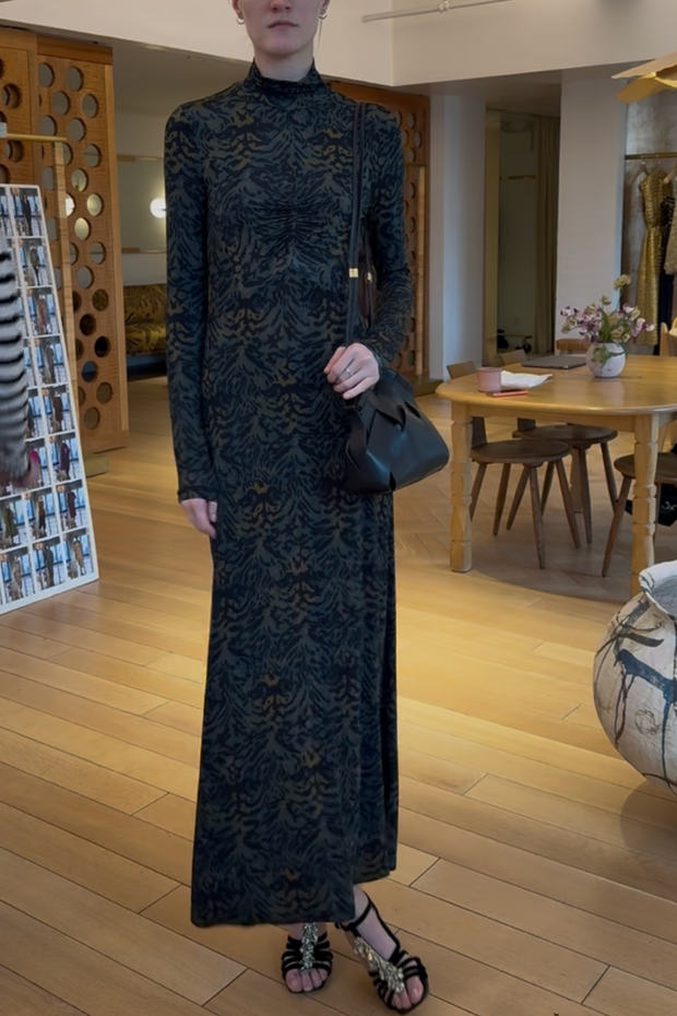 Person wearing a long black lace dress in an indoor setting