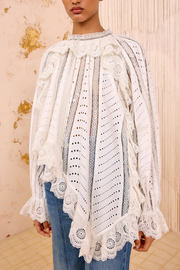 Woman wearing a white lace top with a blurred background
