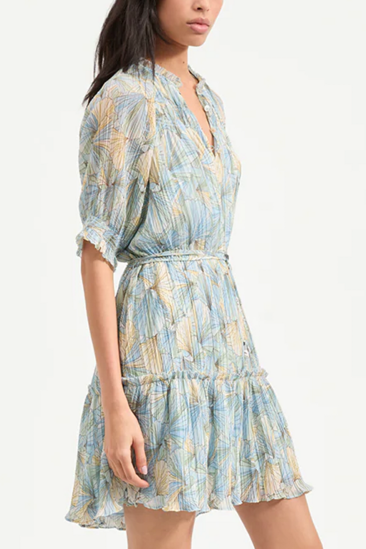 Woman wearing a blue and green patterned dress on a white background