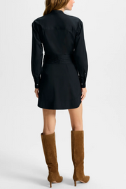 Black dress worn by a person, paired with brown knee-high boots on a white background