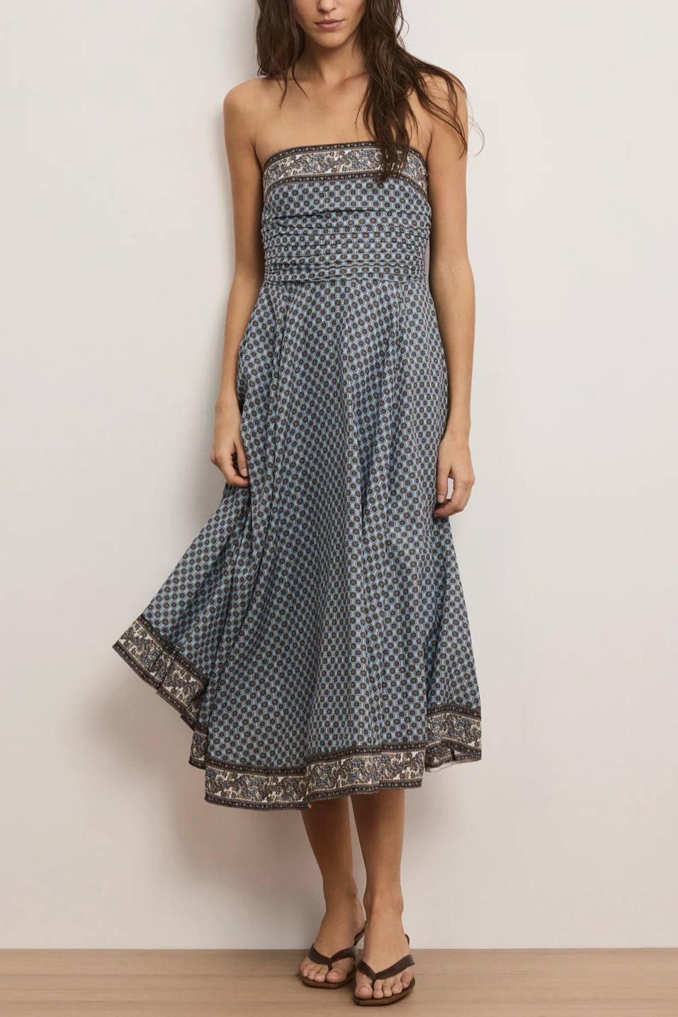 women wearing a blue dress with patterns and flip flops 