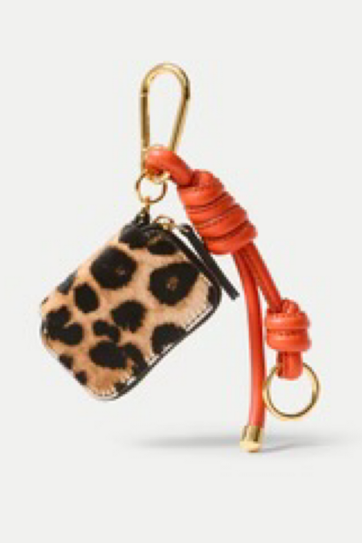 Leopard print pouch with orange strap and gold hardware on a white background