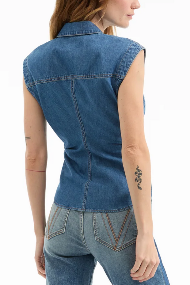 Denim vest worn by a person on a white background